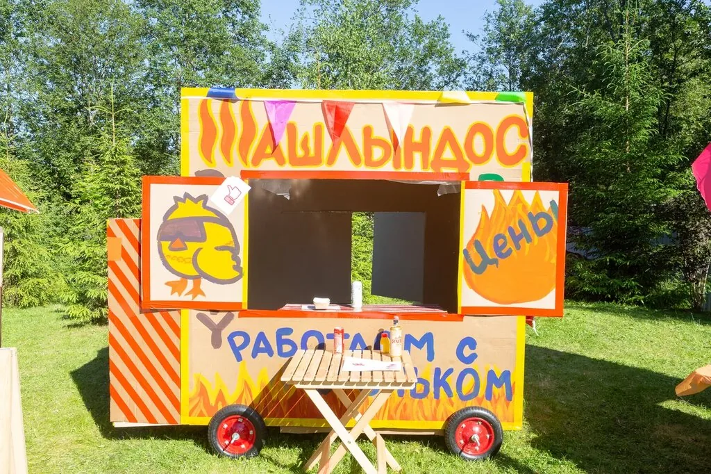 Фудтрак, оформленный командой, в праздничном городке на поляне