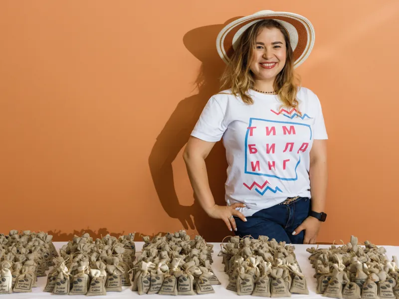 Участница в шляпе у стола с мешочками кофе