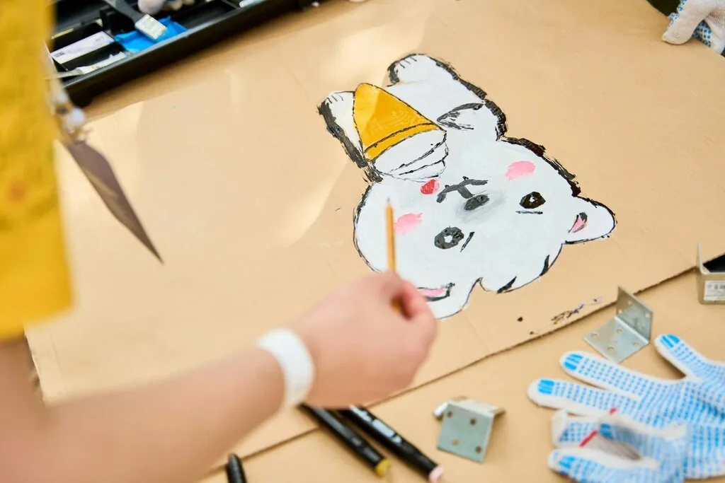 Участница рисует персонажа на картоне
